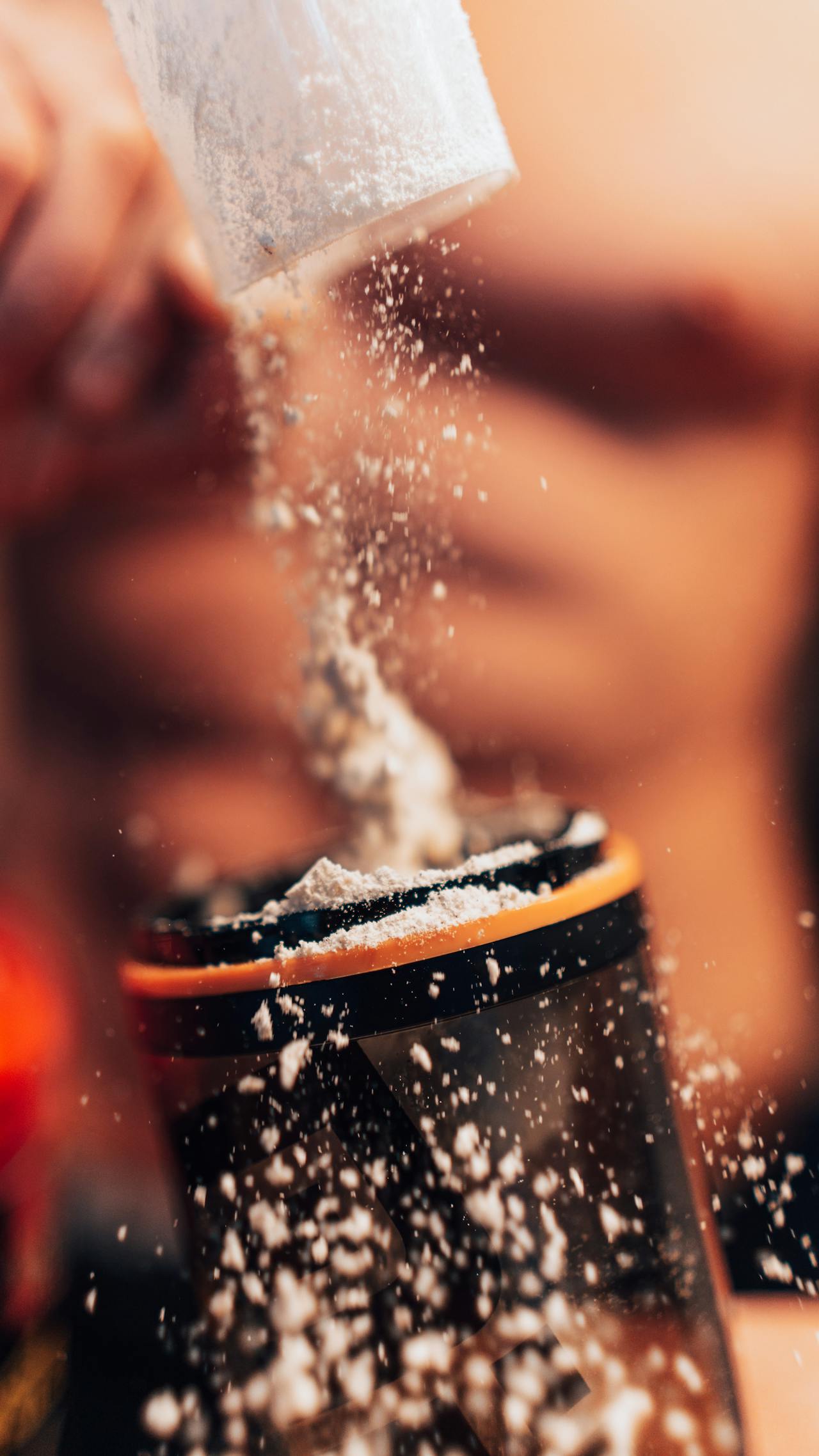 Close-up of pre-workout powder being scooped into container