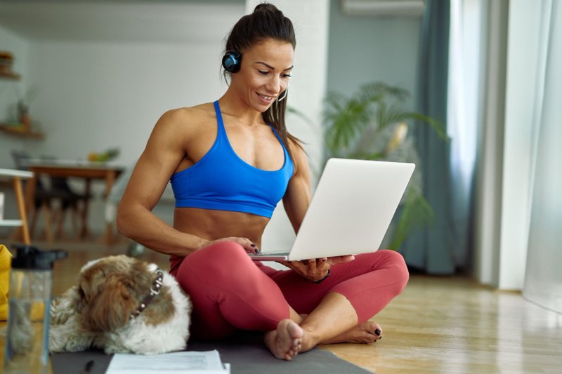 My PT Hub App Review: Online fitness coach working from home using laptop to manage training programs and clients