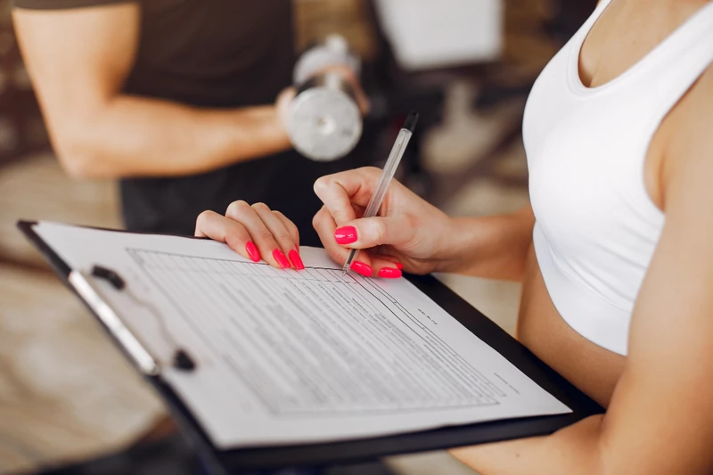 Zenfit Review:Female athlete filling out fitness progress chart during training session.