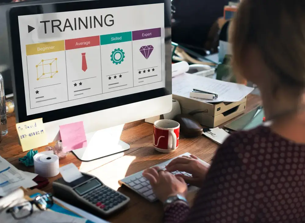 Online training progress showing beginner, average, skilled, and expert levels on a desktop monitor
