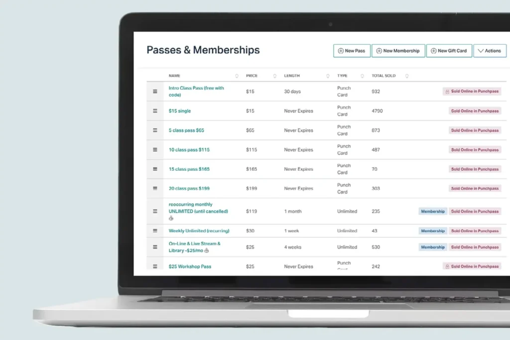 Punchpass passes and memberships dashboard on laptop screen showing different class pass options, prices, expiration details, total sold, and membership types for fitness studios.